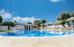 a large swimming pool with chairs and umbrellas at Villa Parisi con piscina in Syracuse