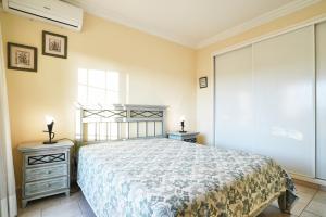 a bedroom with a bed and two night stands and a window at Sunset Villa in Ferragudo +11 photos