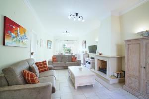 a living room with a couch and a fireplace at Sunset Villa in Ferragudo