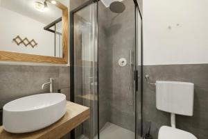 a bathroom with a sink and a glass shower at Maison Olga - La Roisette in Valtournenche