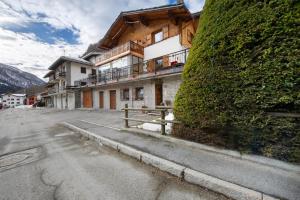 a building on the side of a street with a hedge at Maison Olga - La Roisette in Valtournenche