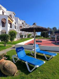 two beach chairs and an umbrella and a slide at Binimar - Cala en Porter in Cala en Porter