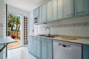 a kitchen with blue and white cabinets and a table at La Terrassa vistas al mar in Cambrils