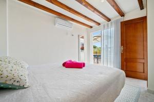 a bedroom with a bed with a pink object on it at La Terrassa vistas al mar in Cambrils