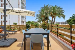 a table with chairs and an umbrella on a balcony at La Terrassa vistas al mar in Cambrils