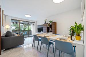 a dining room with a table and chairs and a couch at La Terrassa vistas al mar in Cambrils