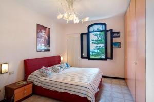a bedroom with a red bed and a window at Wonderful flat by sea chez Monique in Bordighera