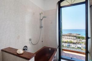 a bathroom with a tub and a shower with a view at Wonderful flat by sea chez Monique in Bordighera