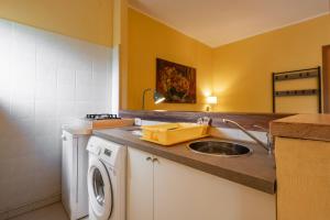 a kitchen with a sink and a washing machine at Rosaspina - Appartamento 4 in Capalbio