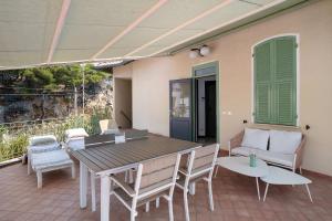 a patio with a table and chairs and a couch at Wonderful flat by sea chez Monique in Bordighera +14 photos
