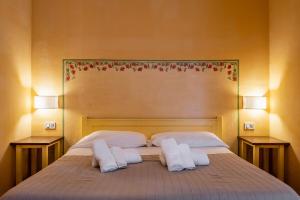 a bedroom with a bed with two pillows and two lamps at Rosaspina - Appartamento 4 in Capalbio +15 photos