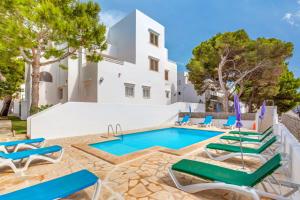 a villa with a swimming pool and lounge chairs at Apartamentos Karin 2ºd in Cala d´Or