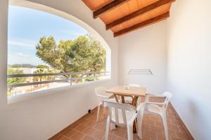a dining room with a table and chairs and a large window at Apartamentos Karin 2ºd in Cala d´Or