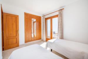 a bedroom with two beds and an open door at Apartamentos Karin 2ºd in Cala d´Or +17 photos