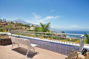 a white bench sitting on a balcony overlooking the ocean at Casa Ana in Santa Úrsula