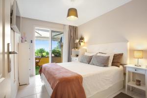 a bedroom with a white bed and a balcony at Casa Ana in Santa Úrsula +25 photos