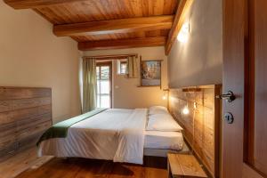 a bedroom with a bed in a room with wooden ceilings at Civico 11 in Marmora +5 photos