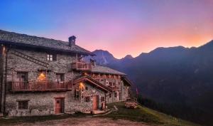 a building on a mountain with a sunset in the background at Civico 11 in Marmora