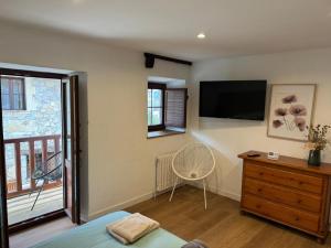 a bedroom with a tv on the wall and a dresser at Casa Eider in Rucandio