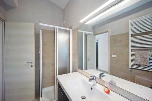 a bathroom with a sink and a shower and a mirror at Mansarda Albero Verde con Piscina in Casanova Lerrore +17 photos
