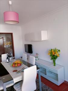 a dining room with a table and white chairs at Valley T2 duplex in Vila Nova de Foz Coa