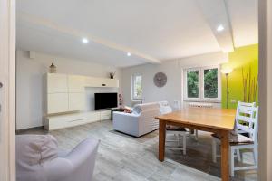 a living room with a wooden table and a dining room at Sweet Home Apartments Bambù in Arona