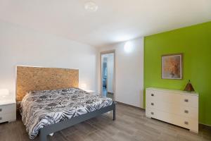a bedroom with a bed and a green wall at Sweet Home Apartments Bambù in Arona