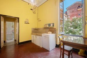 a kitchen with yellow walls and a counter and a table at Piazza 100 Croci in Bonassola +46 photos