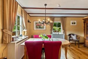 a dining room with a table and purple chairs at Tannenhäuschen Sauerland in Schmallenberg
