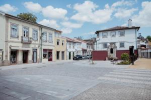 an empty street in a town with white buildings at Fonte do Pinheiro Boutique in Ponte de Lima