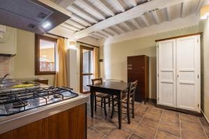 a kitchen with a stove and a table with chairs at Rosaspina - Appartamento 2 in Capalbio