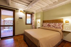 a bedroom with a large bed and a balcony at Rosaspina - Appartamento 2 in Capalbio +21 photos