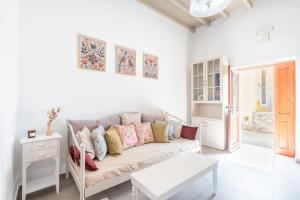a white living room with a couch and a table at Rodies House in Rhodes Town