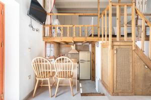 a kitchen with a table and two chairs and a staircase at Rodies House in Rhodes Town
