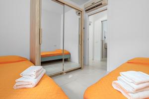 a bedroom with two beds and a mirror at Cormorani - Appartamento 8 in Golfo Aranci