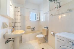 a white bathroom with a sink toilet and a window at Olivea Apt 1 in Acharavi