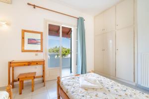 a bedroom with a bed and a desk and a window at Olivea Apt 1 in Acharavi