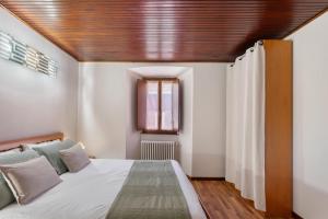 a bedroom with a large bed with a wooden ceiling at Il Vicolino in Pettenasco