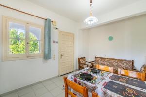 a bedroom with a table and chairs and a window at Olivea Apt 1 in Acharavi +20 photos