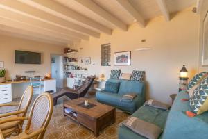a living room with a blue couch and a table at Mon nid d'aigle in Olmeto