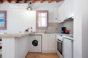 a white kitchen with a washer and dryer at Nicolas House 1 in Rakhídhion +17 photos