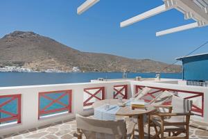 a table and chairs on a balcony with a view of the ocean at Nicolas House 1 in Rakhídhion