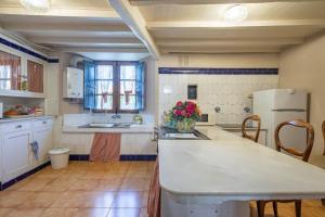 a kitchen with a white refrigerator and a counter top at Casa La Calleja in Arzúa +19 photos