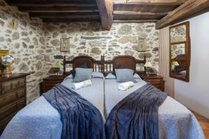 a bedroom with a bed with two pillows on it at Casa La Calleja in Arzúa
