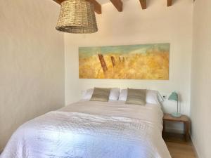 a bedroom with a bed with a painting on the wall at Son Pelai Menut in Lloseta
