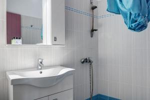 a bathroom with a sink and a mirror and a shower at Nicolas House 3 in Rakhídhion +15 photos