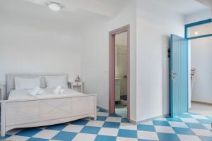 a bedroom with a bed and a checkered floor at Nicolas House 3 in Rakhídhion