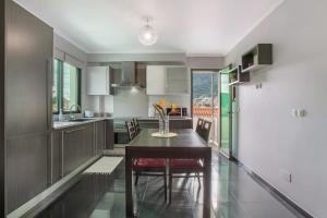 a kitchen with a dining room table and chairs at Apartamento Eden in Machico