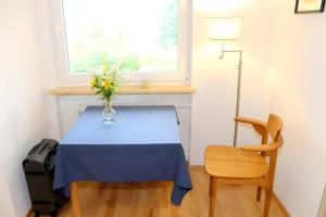 a blue table with a vase of flowers and a chair at Ferienwohnung Jachmann, 80qm in Schönwald
