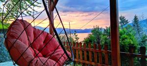 a hammock on a porch with a view of a lake at Smart Nature in Donji Milanovac